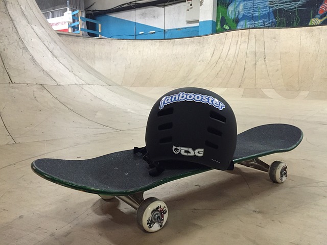 A skateboard and helmet sit on the floor of a skate park